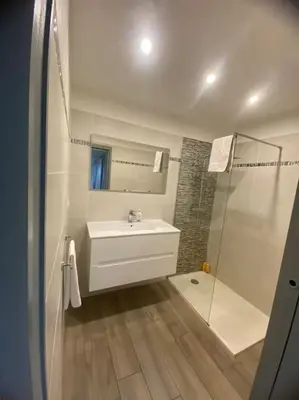 a white bathroom with a sink and a shower at Appartement F4 pour 6 personnes in Ajaccio
