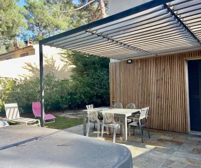 a patio with a table and chairs under a pergola at Maison T4 Saint Cyprien in Lecci