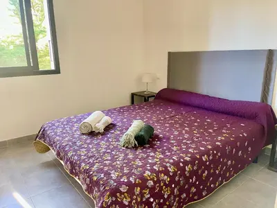 a bedroom with a purple bed with two stuffed animals on it at Maison T4 Saint Cyprien in Lecci