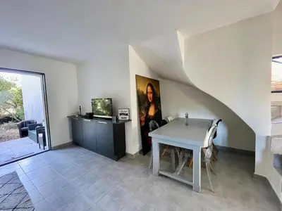 a living room with a white table and a wall at Maison T4 Saint Cyprien in Lecci
