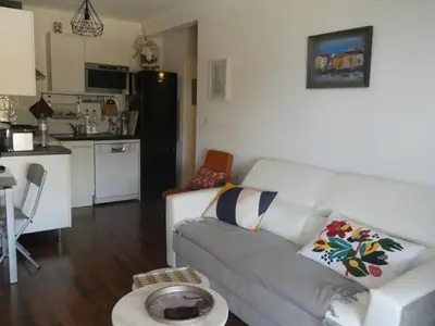a living room with a couch and a kitchen at Ajaccio Sanguinaires T2 150métres de la mer in Ajaccio