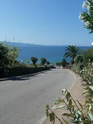 an empty road with the ocean in the background at Ajaccio Sanguinaires T2 150métres de la mer in Ajaccio