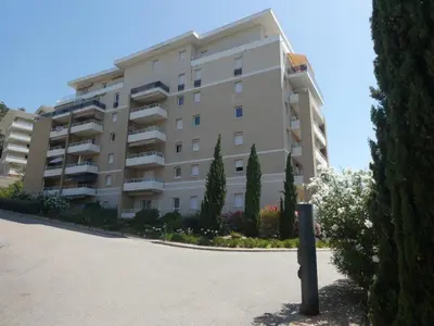 a large apartment building with trees in front of it at Ajaccio Sanguinaires T2 150métres de la mer in Ajaccio