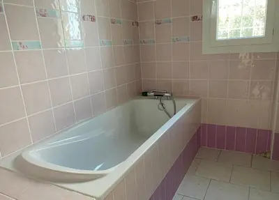 a bath tub in a pink tiled bathroom at Baignoire in Cuttoli-Corticchiato