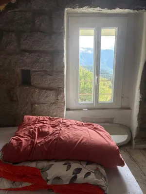 a bed in a room with a window at Maison de village in Zevaco