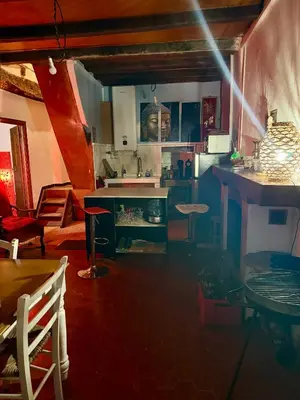 a kitchen with a counter and a table in a room at Maison de village in Zevaco