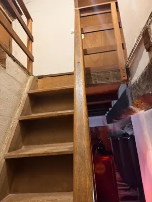 an open stairwell in a room with wooden shelves at Maison de village in Zevaco