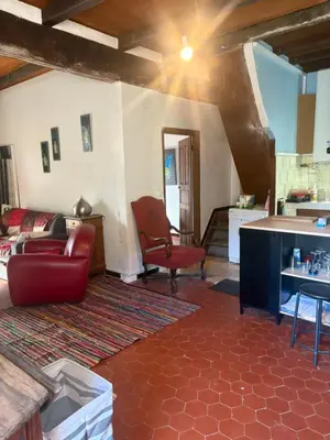 a living room with a red chair and a couch at Maison de village in Zevaco