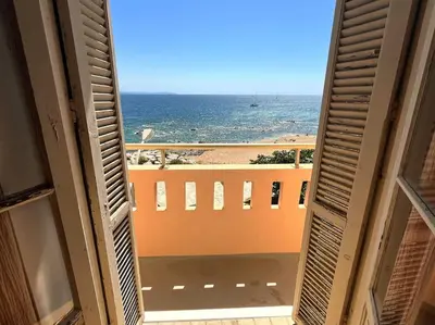 a view of the ocean from the balcony of a building at T4 Pieds dans l'eau ! in Ajaccio