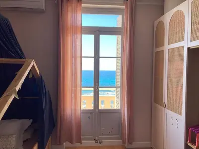 a bedroom with a window with a view of the ocean at T4 Pieds dans l'eau ! in Ajaccio