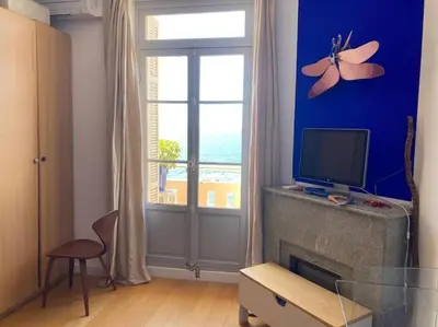 a living room with a flat screen tv and a window at T4 Pieds dans l'eau ! in Ajaccio
