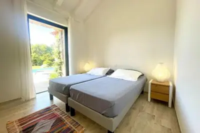 a bedroom with a bed and a large window at Villa à Marina di Fiori - 8 pers in Porto-Vecchio