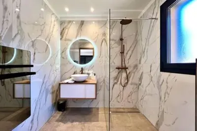a bathroom with a shower with a sink and a mirror at Casa di Macchjerolu - 8 pers in Sotta