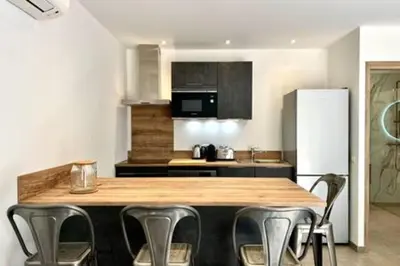 a kitchen with a counter with chairs and a refrigerator at Casa di Macchjerolu - 8 pers in Sotta