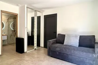 a living room with a couch and a mirror at Casa di Macchjerolu - 8 pers in Sotta
