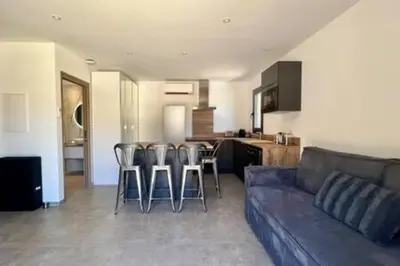 a living room with a couch and some bar stools at Casa di Macchjerolu - 8 pers in Sotta