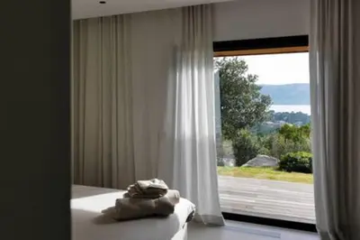 a bedroom with a bed and a large window at Villa Wooden Horizon - Mer Montagne 18 pers in Porto-Vecchio