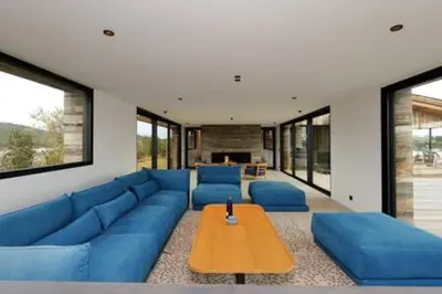 a living room with blue couches and a wooden table at Villa Wooden Horizon - Mer Montagne 18 pers in Porto-Vecchio