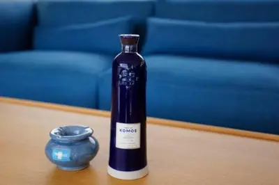 a bottle of wine sitting on a table next to a blue container at Villa Wooden Horizon - Mer Montagne 18 pers in Porto-Vecchio
