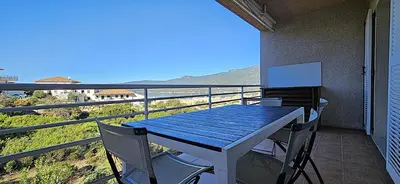 a table and chairs on a balcony with a view of the ocean at Beau T3 Central - Vue mer & Piscine - A Funtana in Propriano