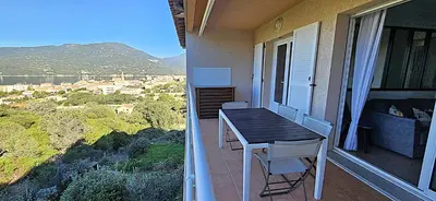 a table and chairs on a balcony with a view at Beau T3 Central - Vue mer & Piscine - A Funtana in Propriano