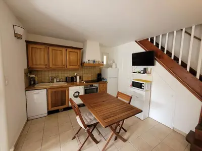 a small kitchen with a wooden table and a sink at Maison au bord de la mer in Poggio-Mezzana