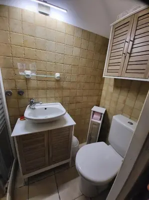 a bathroom with a white toilet and a sink at Maison au bord de la mer in Poggio-Mezzana