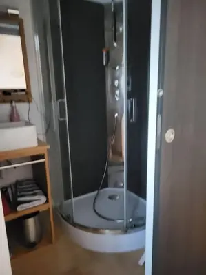 a shower with a glass door in a bathroom at Maison au bord de la mer in Poggio-Mezzana