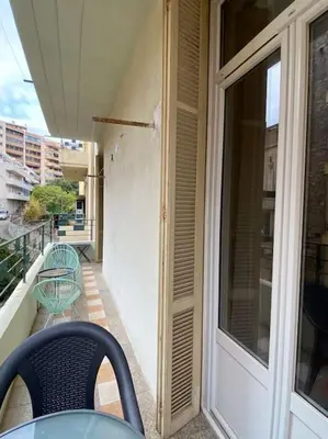 a balcony with a table and chairs and a window at appartement Cyrnos 3Pc 73m2 in Ajaccio