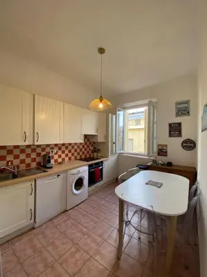 a kitchen with a table and a table and a kitchen with a sink at appartement Cyrnos 3Pc 73m2 in Ajaccio