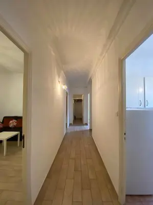 a hallway with white walls and a hallway with a table at appartement Cyrnos 3Pc 73m2 in Ajaccio