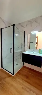 a bathroom with a glass shower and a sink at U Paradisu - Magnifique T4, les pieds dans l'eau in Viagenti