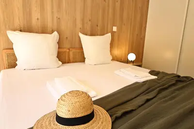 a hat sitting on a bed in a hotel room at U Paradisu - Magnifique T4, les pieds dans l'eau in Viagenti