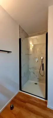 a bathroom with a shower with a stone wall at U Paradisu - Magnifique T4, les pieds dans l'eau in Viagenti