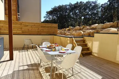 a patio with a table and chairs on a deck at U Paradisu - Magnifique T4, les pieds dans l'eau in Viagenti