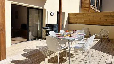 a white table and chairs on a patio at U Paradisu - Magnifique T4, les pieds dans l'eau in Viagenti