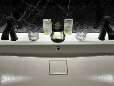 a counter with four cups on top of a sink at appartement de standing avec jacuzzi exterieur in Zonza