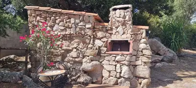 a stone building with a small oven in it at Cottage bergerie en pierres avec jacuzzi en corse 6 personnes, 3 chambres in Coti-Chiavari