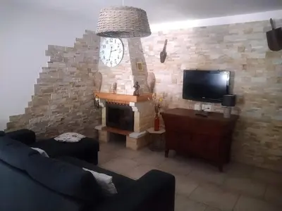 a living room with a large clock on a brick wall at Cottage bergerie en pierres avec jacuzzi en corse 6 personnes, 3 chambres in Coti-Chiavari