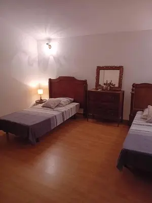 a bedroom with two beds and a dresser and a mirror at Cottage bergerie en pierres avec jacuzzi en corse 6 personnes, 3 chambres in Coti-Chiavari