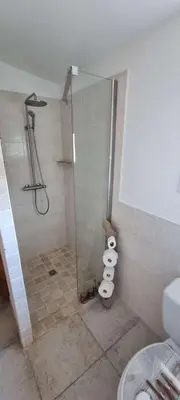 a bathroom with a shower with a glass door at Cottage bergerie en pierres avec jacuzzi en corse 6 personnes, 3 chambres in Coti-Chiavari
