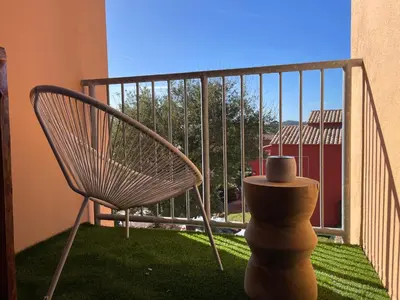 a chair sitting on a balcony with a view at Appartement CERICA proche de la plage de Saint Cyprien in Lecci