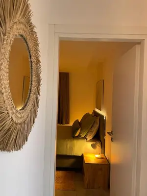 a bedroom with a bed and a mirror on the wall at Appartement CERICA proche de la plage de Saint Cyprien in Lecci