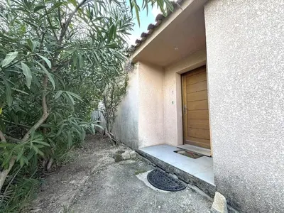 a door to a house with a sidewalk next to it at Appartement avec vue imprenable sur la mer, terrasse et piscine in Propriano