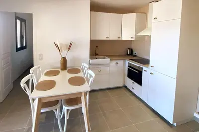 a kitchen with a table and chairs in a room at Rez de villa Favone in Conca
