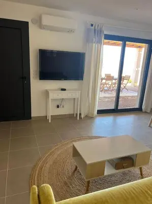 a living room with a tv and a table at Rez de villa Favone in Conca