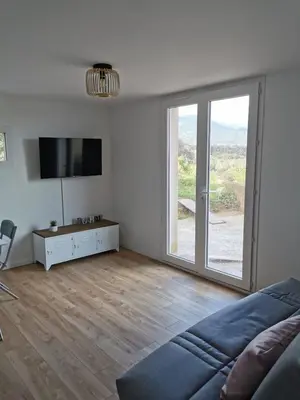 a living room with a large sliding glass door at Appartement neuf dans hameau proche porto vecchio in Porto-Vecchio