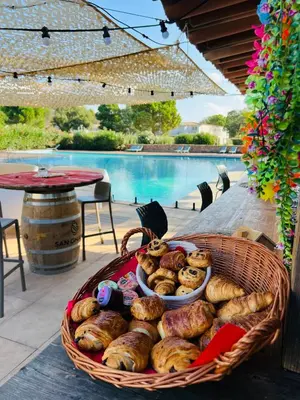 a basket of bread sitting on a table next to a pool at Location T2 44 m2 proche plage Lecci appartement 82 in Lecci