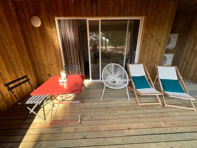 a red table and two chairs on a deck at Location T2 44 m2 proche plage Lecci appartement 82 in Lecci
