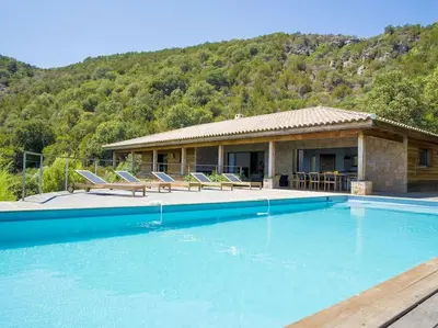 a house with a swimming pool in front of a house at Villa Palombaggia in Porto-Vecchio